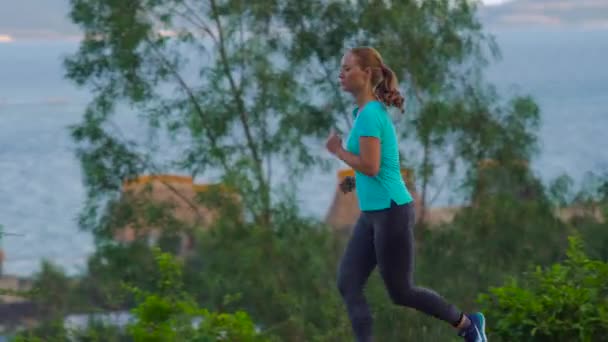 Молода жінка біжить в тропіках — стокове відео