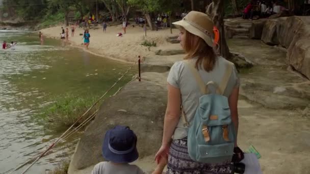 Mamma och ung son går på en riverside — Stockvideo