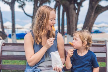 Anne ve oğlu tatlı patates kızartması yemek 