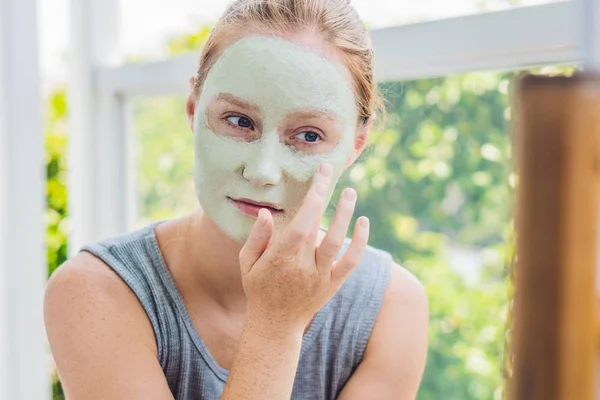 Mujer aplicando Facial máscara de arcilla verde — Foto de Stock