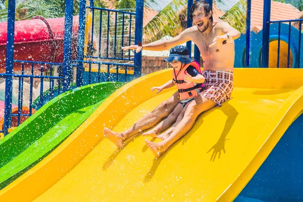 Father and son on a water slide — Stock Photo, Image