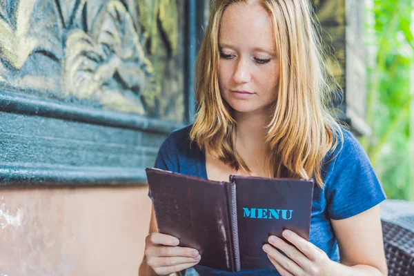 Beautiful woman ordering from menu — Stock Photo, Image