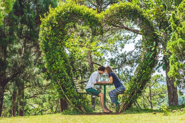 Casal amoroso sob um arbusto — Fotografia de Stock