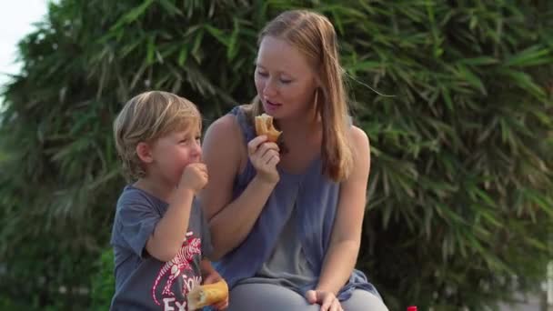 Mãe e filho comem batatas doces fritas — Vídeo de Stock