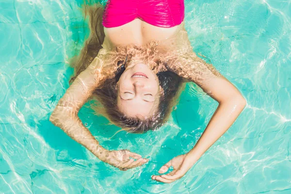 Mulher bonita flutuando na piscina — Fotografia de Stock