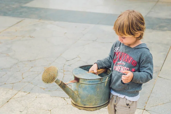 Little boy watering flowers watering can. — Stock Photo, Image