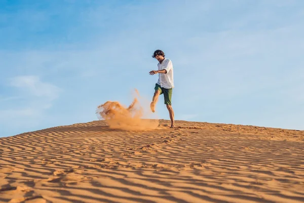 Man is kicking sand in a red desert — Stock Photo, Image