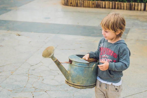 Little boy watering flowers watering can. — Stock Photo, Image