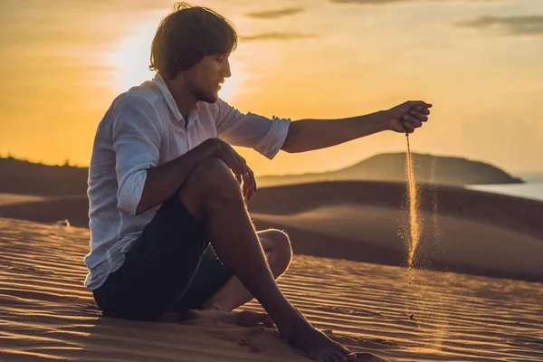 Человек посыпает песок в пустыне — стоковое фото