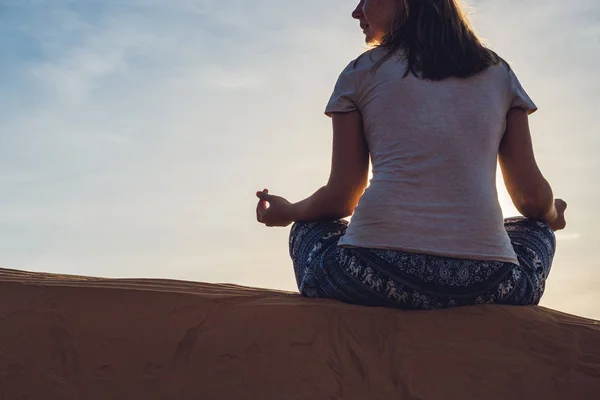 Jonge vrouw mediteren bij zonsondergang — Stockfoto