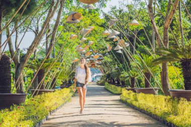 Genç kadın turist ve Vietnamca şapkalar