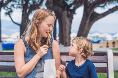 Anne ve oğlu tatlı patates kızartması yemek 