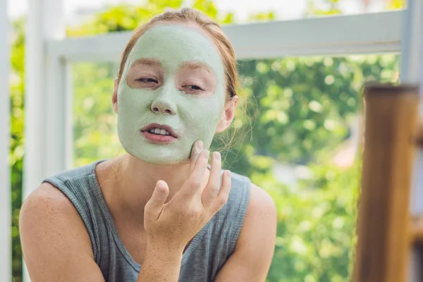 Mujer aplicando Facial máscara de arcilla verde — Foto de Stock