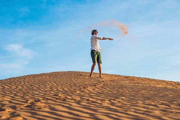 Adam kırmızı bir çölde kum tekme atıyor — Stok fotoğraf