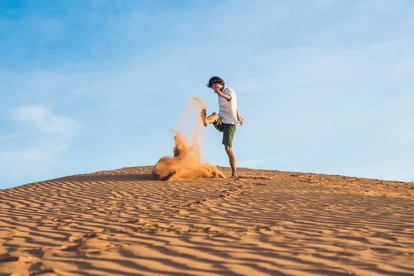 Man is kicking sand in a red desert — Stock Photo, Image