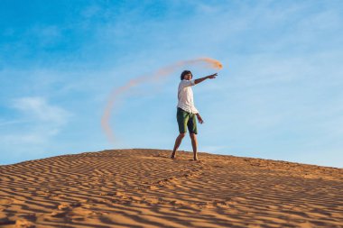 adam kırmızı bir çölde kum tekme atıyor