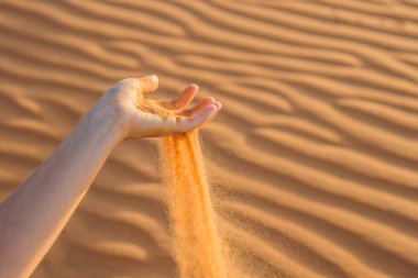 Parmaklarının arasından kayıp kum