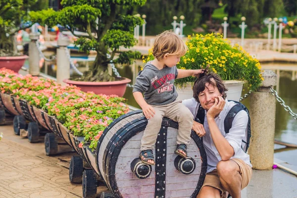 Father and son and a flower bed in the form of a locomotive — Stock Photo, Image