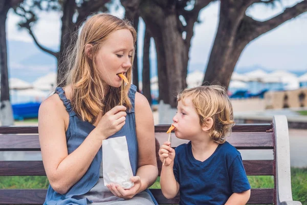 Мама и сын едят жареный сладкий картофель — стоковое фото