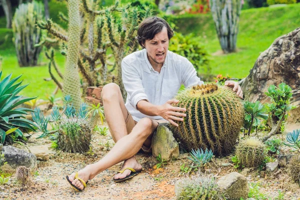 El hombre está sentado entre grandes cactus — Foto de Stock