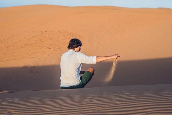 Man is pouring sand in the desert — Stock Photo, Image