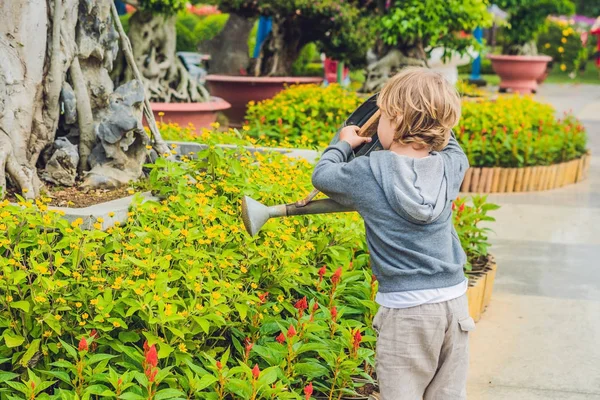 Schattige kleine jongen drenken bloemen — Stockfoto