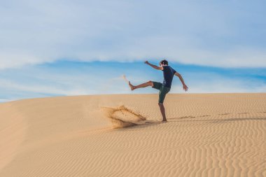 adam kırmızı bir çölde kum tekme atıyor