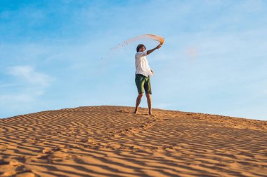adam kırmızı bir çölde kum tekme atıyor