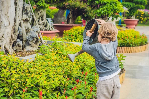 Schattige kleine jongen drenken bloemen — Stockfoto