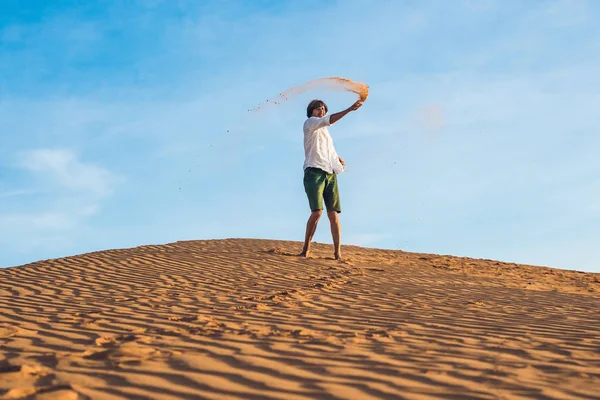 Adam kırmızı bir çölde kum tekme atıyor — Stok fotoğraf
