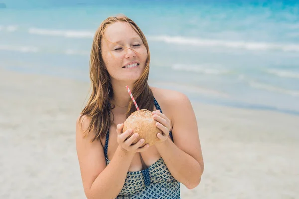 Mujer joven bebiendo leche de coco —  Fotos de Stock