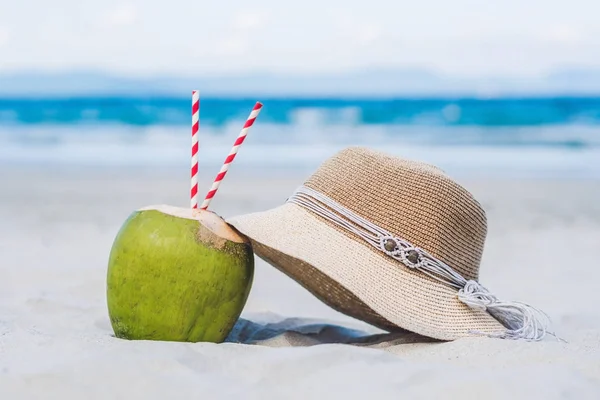 Coconut with straws in the sand — Stock Photo, Image
