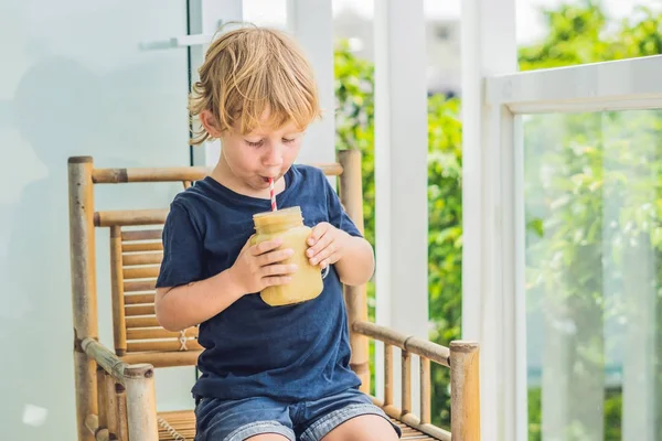 Niño sosteniendo un batido de plátano, concepto de nutrición adecuada — Foto de Stock