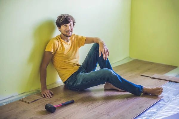 新しいラミネート床をインストールする男 — ストック写真