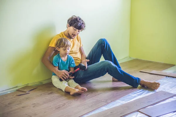 Padre e hijo instalando pisos laminados . — Foto de Stock