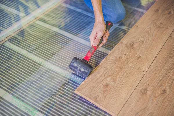 安装新的强化木地板的男人 — 图库照片