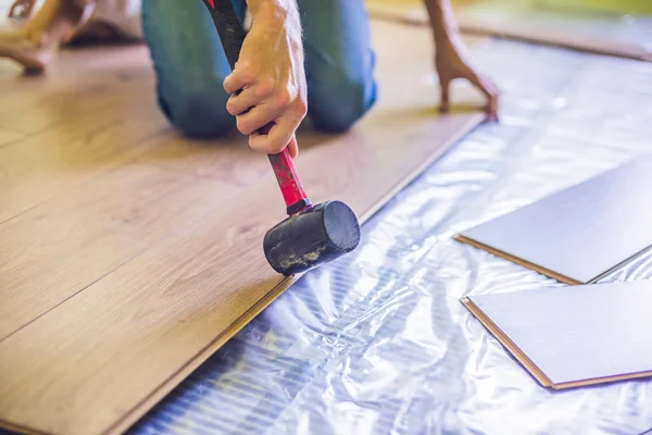 Uomo l'installazione di nuovi pavimenti in laminato — Foto Stock