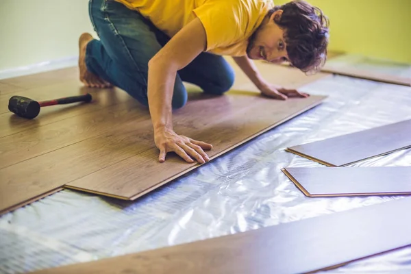 Uomo l'installazione di nuovi pavimenti in laminato — Foto Stock