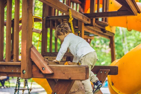 Хлопчик грає на дерев'яному майданчику — стокове фото