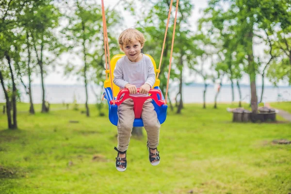 Kleine jongen rijden op een schommel — Stockfoto