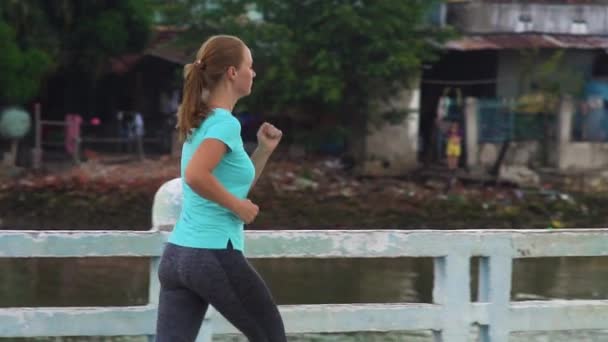 Junge Frau engagiert sich beim Laufen — Stockvideo