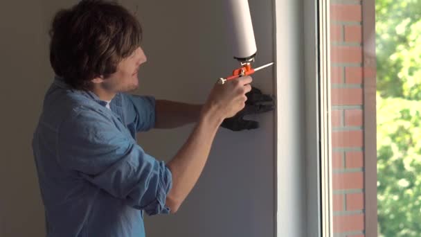 Man in doet venster installatie — Stockvideo