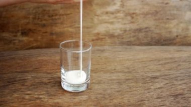 Kadın yoğurt bir cam koyar.