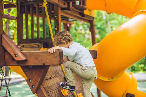 Junge spielt auf Holzspielplatz — Stockfoto