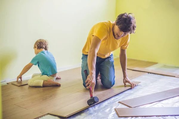 Padre e figlio l'installazione di pavimenti in laminato . — Foto Stock