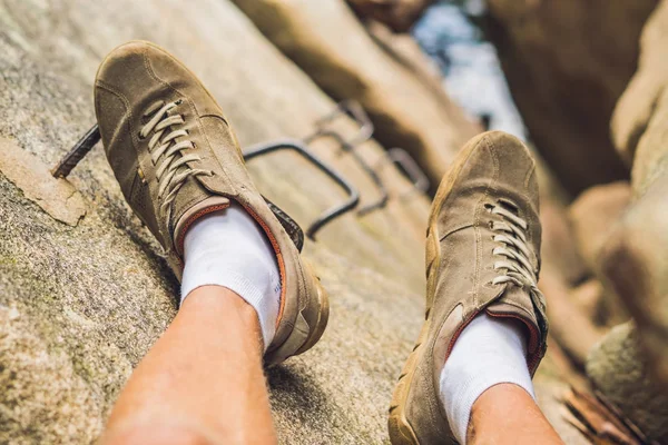 Legs of traveler on on a rock — Stock Photo, Image