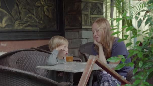 Женщина и ее сын пьют цитрусовый чай — стоковое видео