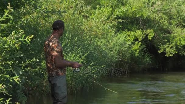 Man fiskar på en berg flod med ett ultralätt spinning med fiske wobblers — Stockvideo