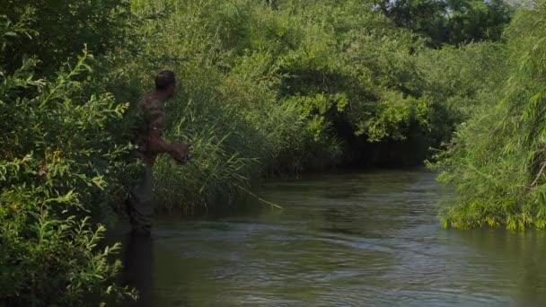 Homem pescando em um rio de montanha com um fiação ultraleve usando osciladores de pesca — Vídeo de Stock