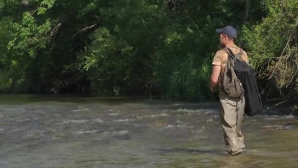 L'uomo pesca su un fiume di montagna con una filatura ultraleggera utilizzando wobblers pesca. Ha preso il suo amo per qualcosa. — Video Stock